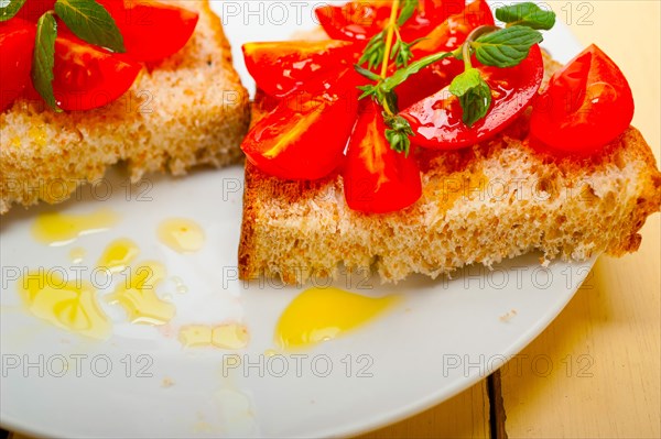 Italian tomato bruschetta with thyme and mint leaves