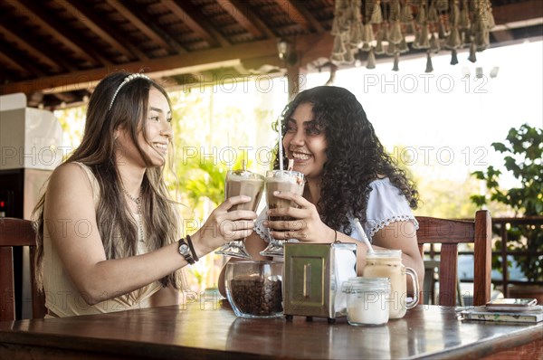 Two girls drink a milkshake