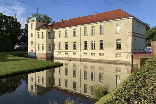 View of classicist castle Westerholt with reflection of building in historical moat