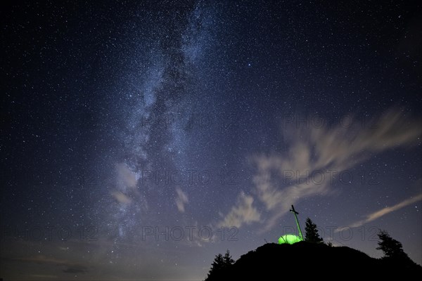 Green tent with summit cross under a starry sky on Portlakopf