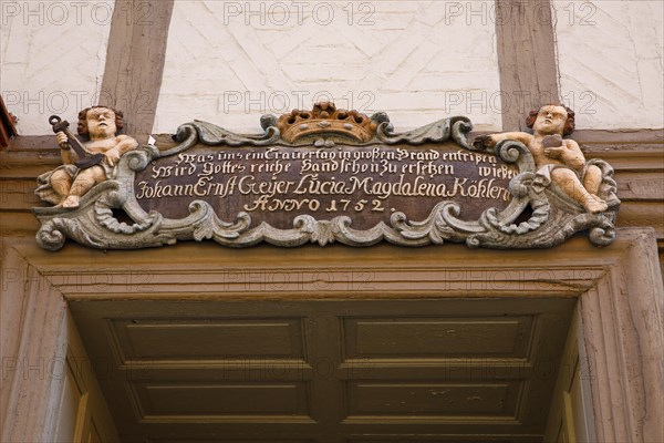 Baroque cartouche with putti above old wooden door