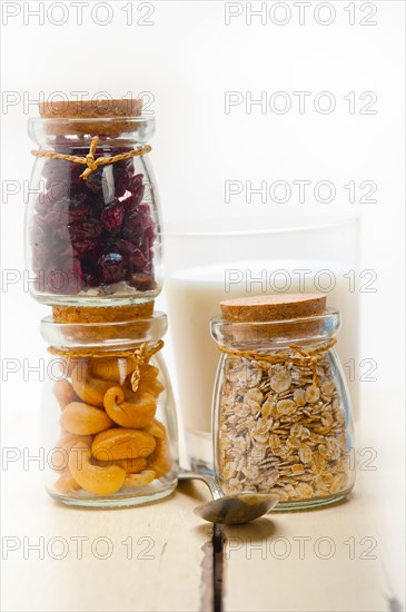 Healthy breakfast ingredients milk oat cashew nuts dried cramberry craisinns