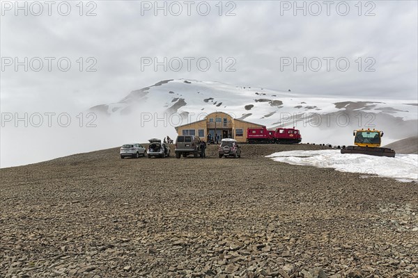 Four-wheel drive vehicles on car park in front of mountain hotel Joeklasel in summer