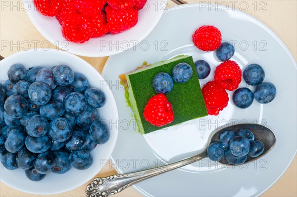 Green tea matcha mousse cake with raspberries and blueberries on top