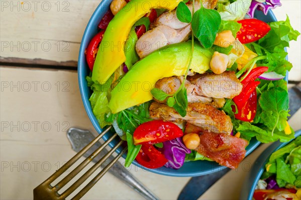 Fresh and healthy Chicken Avocado salad over rustic wood table