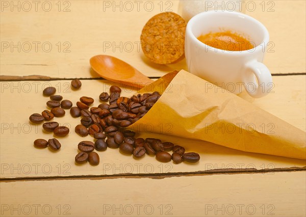 Espresso coffee and beans on a paper cone cornucopia over white background