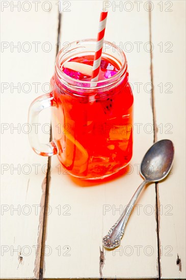 Fresh fruit punch refreshing summer drink over white rustic wood table