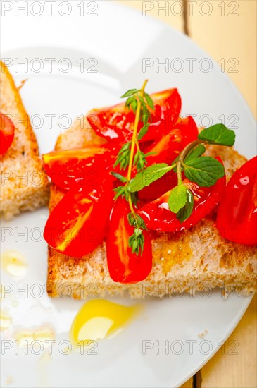 Italian tomato bruschetta with thyme and mint leaves