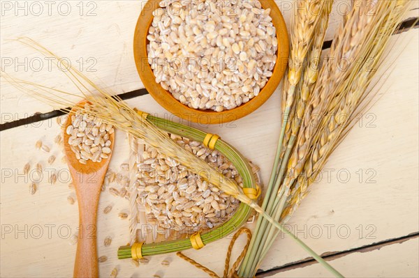 Organic barley grains over rustic wood table macro closeup