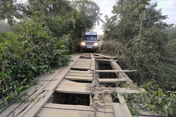 Off-road vehicle in front of a broken wooden bridge on the Transpantaneira