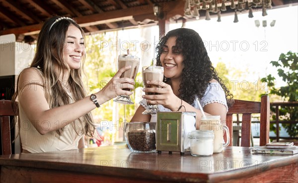 Two girls drink a milkshake