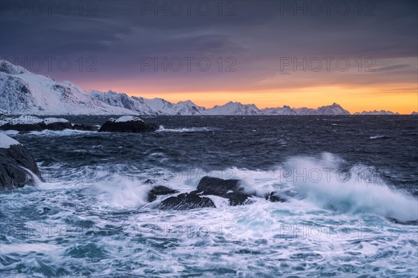 Waves and snowy coast at Hamnoy at sunrise