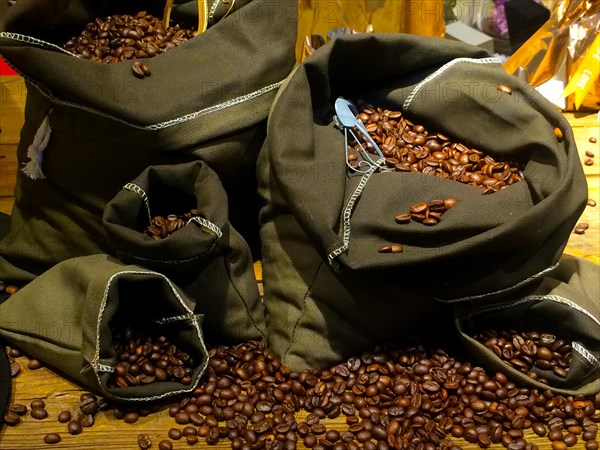 Coffee beans on bags over rustic wood background