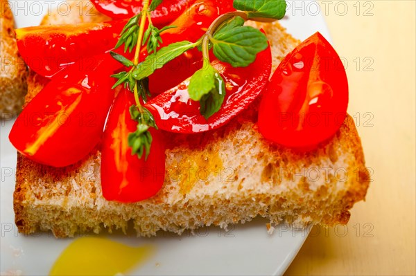 Italian tomato bruschetta with thyme and mint leaves