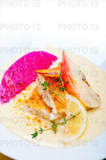 Sea bream orata fillet butter pan fried with fresh peach prune and dragonfruit slices thyme on top