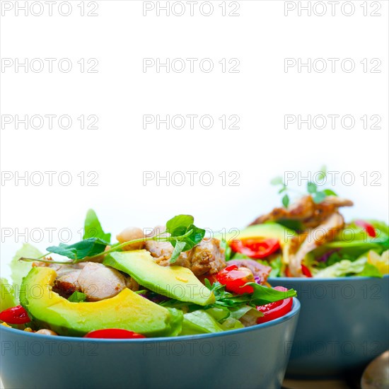 Fresh and healthy Chicken Avocado salad over rustic wood table