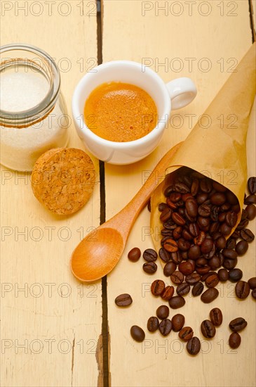 Espresso coffee and beans on a paper cone cornucopia over white background