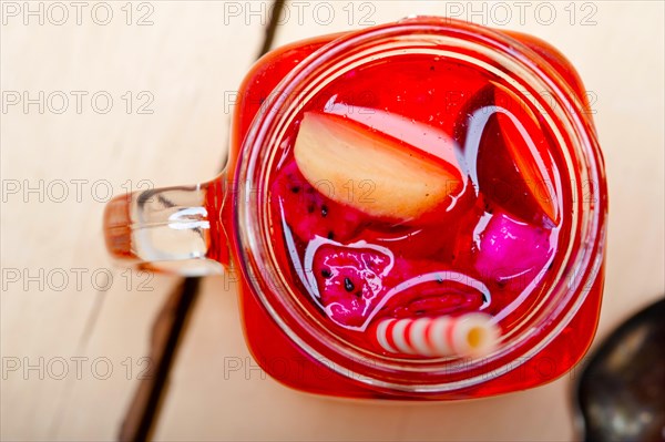 Fresh fruit punch refreshing summer drink over white rustic wood table