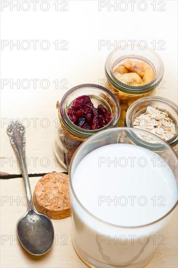 Healthy breakfast ingredients milk oat cashew nuts dried cramberry craisinns