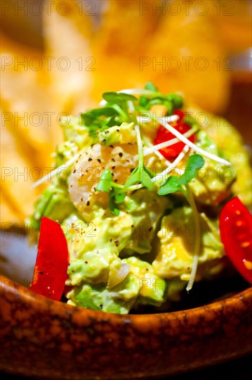 Fresh avocado and shrimps salad with nachos on side