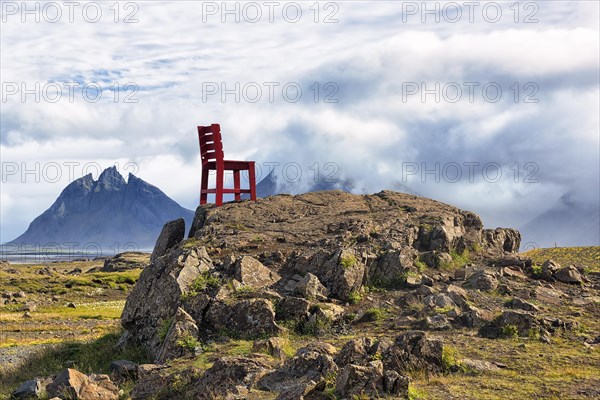 Red wooden chair on a rock