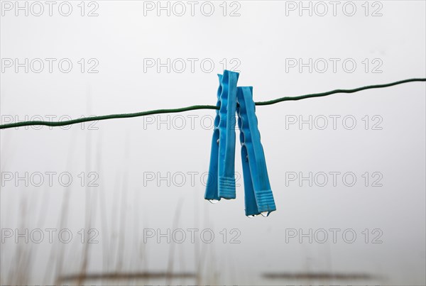Clothes pegs on a rope with water drops