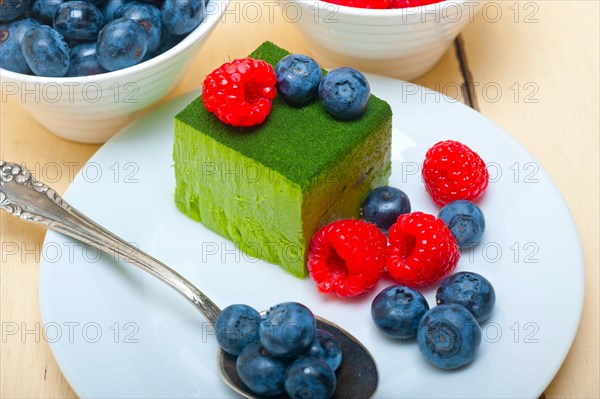 Green tea matcha mousse cake with raspberries and blueberries on top