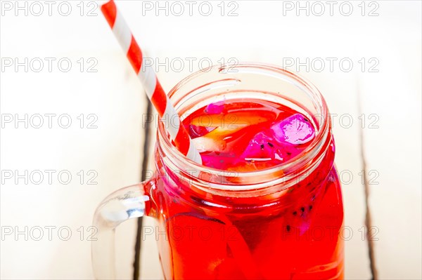 Fresh fruit punch refreshing summer drink over white rustic wood table