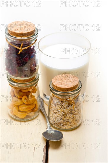 Healthy breakfast ingredients milk oat cashew nuts dried cramberry craisinns