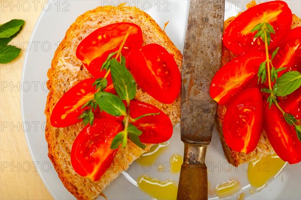 Italian tomato bruschetta with thyme and mint leaves