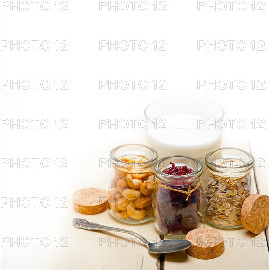 Healthy breakfast ingredients milk oat cashew nuts dried cramberry craisinns