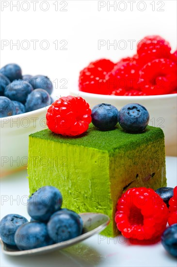 Green tea matcha mousse cake with raspberries and blueberries on top