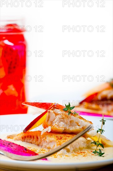 Sea bream orata fillet butter pan fried with fresh peach prune and dragonfruit slices thyme on top