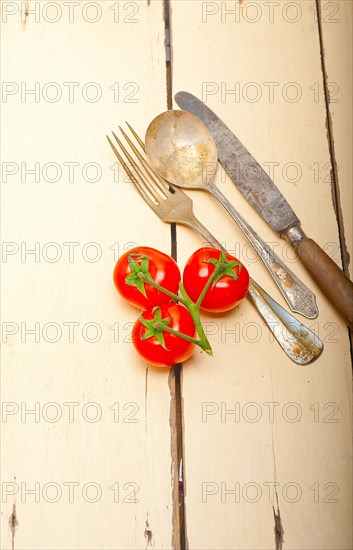 Ripe cherry tomatoes cluster over white rustic wood table