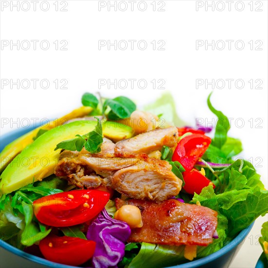 Fresh and healthy Chicken Avocado salad over rustic wood table