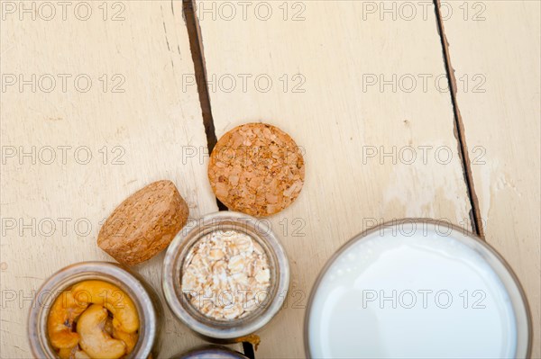 Healthy breakfast ingredients milk oat cashew nuts dried cramberry craisinns