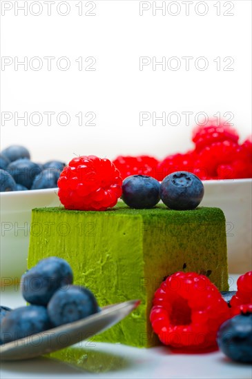 Green tea matcha mousse cake with raspberries and blueberries on top