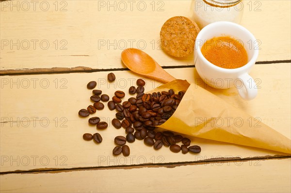 Espresso coffee and beans on a paper cone cornucopia over white background