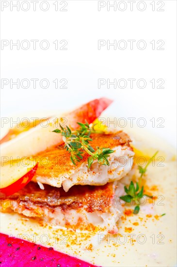 Sea bream orata fillet butter pan fried with fresh peach prune and dragonfruit slices thyme on top