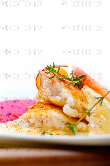 Sea bream orata fillet butter pan fried with fresh peach prune and dragonfruit slices thyme on top