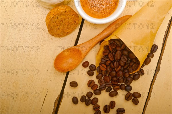 Espresso coffee and beans on a paper cone cornucopia over white background
