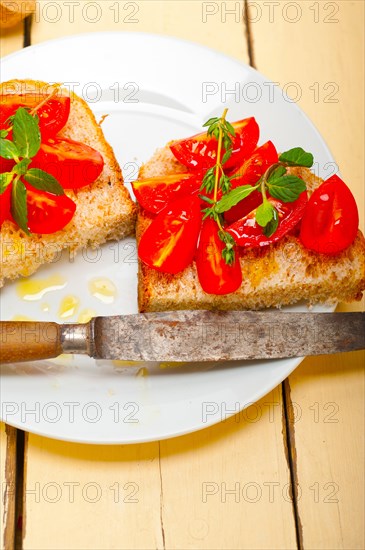 Italian tomato bruschetta with thyme and mint leaves