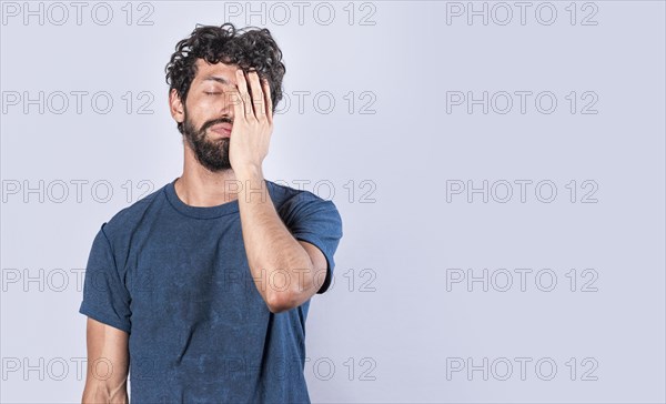 Tired and desperate man covering his face with his hand palm