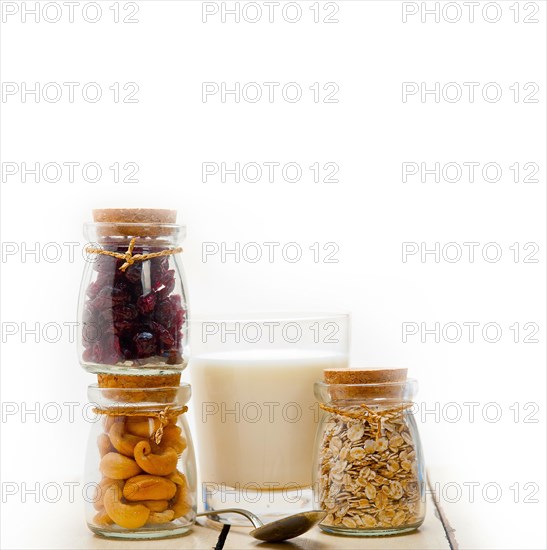 Healthy breakfast ingredients milk oat cashew nuts dried cramberry craisinns