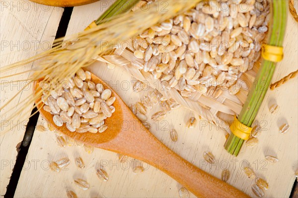 Organic wheat grains over rustic wood table macro closeup