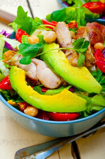 Fresh and healthy Chicken Avocado salad over rustic wood table