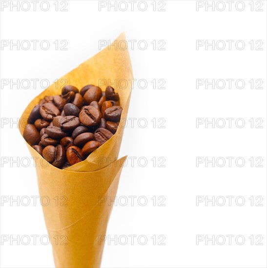 Espresso coffee beans on a paper cone cornucopia over white background