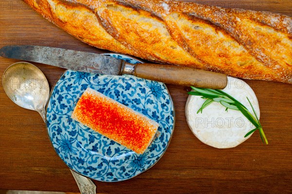 French cheese and fresh baguette on a wood cutter