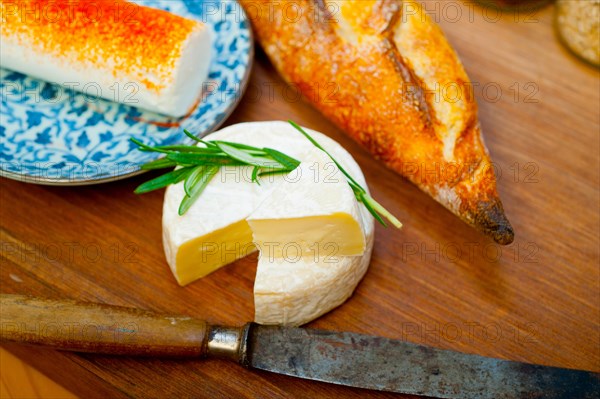 French cheese and fresh baguette on a wood cutter