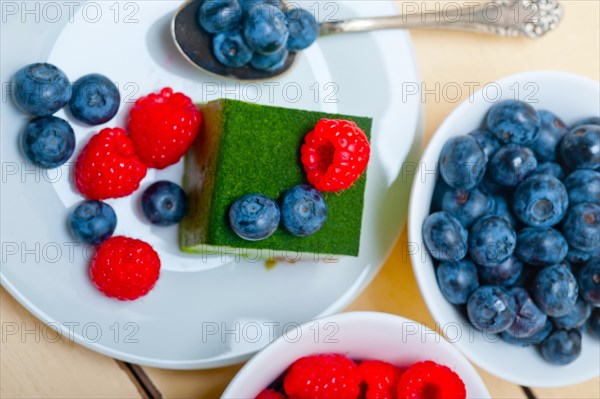 Green tea matcha mousse cake with raspberries and blueberries on top